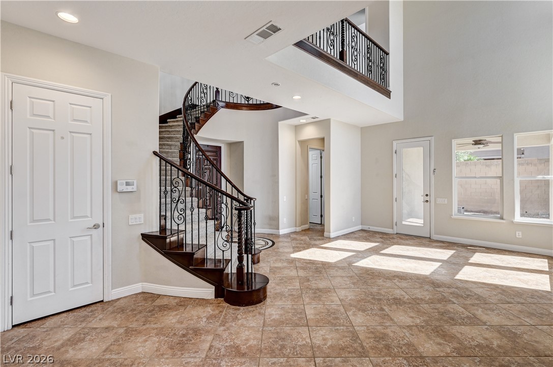 2793 Rosenhearty Drive Henderson, NV 89044 - Photo 74 of 77 A grand spiral staircase commands attention, complementing the open floorplan and high ceilings in this luminous entry.