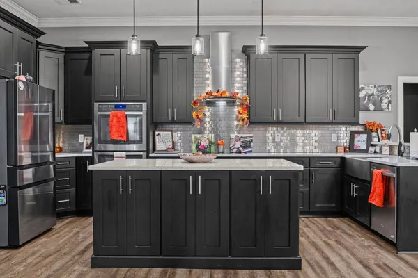 a kitchen with stainless steel appliances granite countertop a refrigerator and a sink