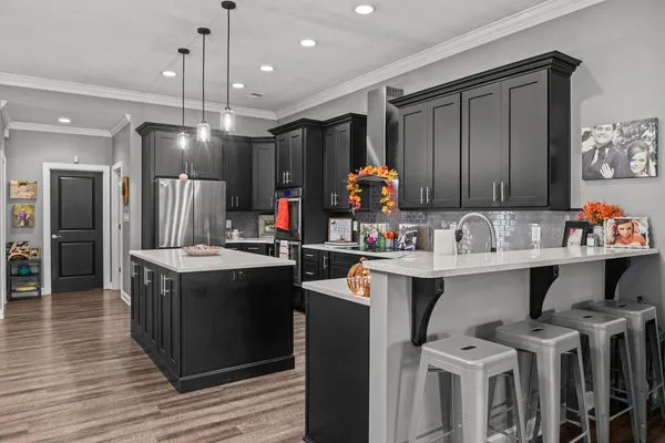 a kitchen with stainless steel appliances granite countertop a sink and a refrigerator
