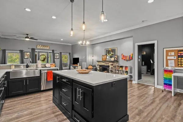 a kitchen with kitchen island a sink and a stove with wooden floor