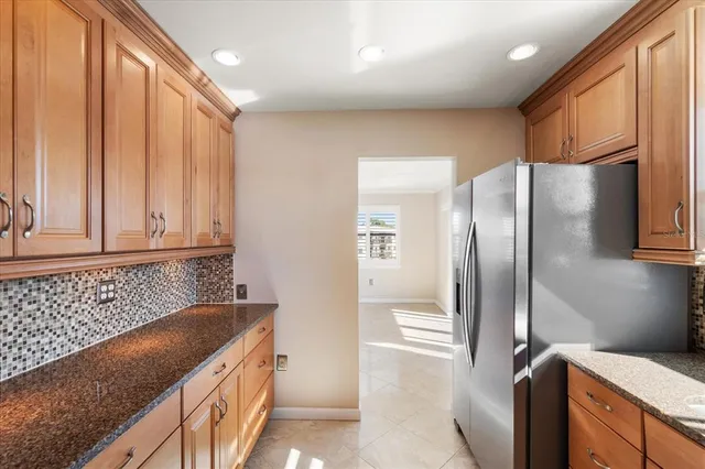a kitchen with stainless steel appliances granite countertop a refrigerator and a sink