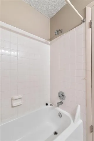 a bathroom with a white bath tub and a shower curtain