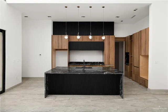 a view of kitchen with stainless steel appliances granite countertop cabinets and window