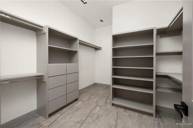 a view of walk in closet with empty racks