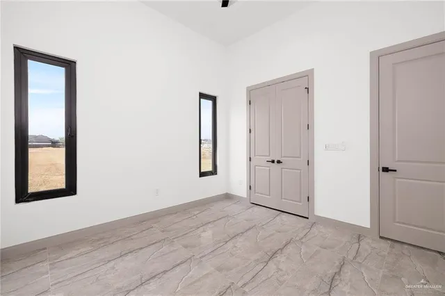 an empty room with windows and closet
