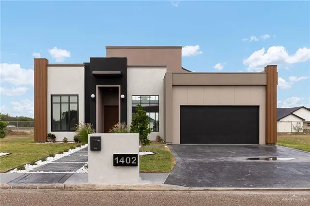 a front view of a house with a garden and garage