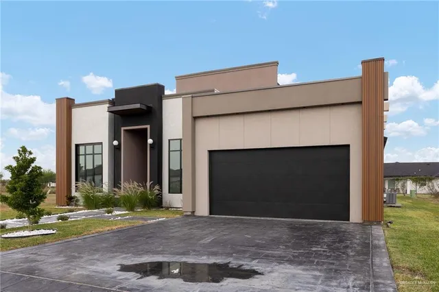 a front view of a house with a yard and a garage