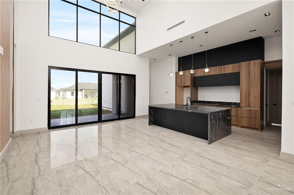 1402 Tierra Encantada Weslaco, TX 78596 - Photo 4 of 29 a kitchen with stainless steel appliances kitchen island granite countertop a refrigerator and a stove