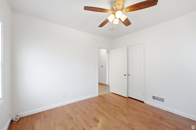 1925 South Main Street Bountiful, UT 84010 - Photo 20 of 48 Hardwood flooring throughout featuring white baseboards, a ceiling fan with light fixture, and white bi-fold closet doors with round hardware