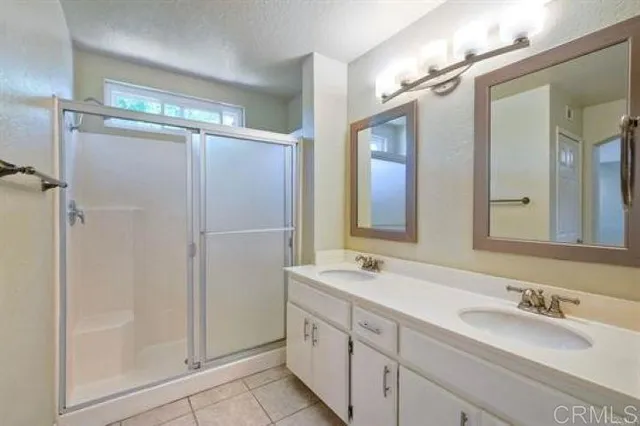 a bathroom with double vanity and a mirror