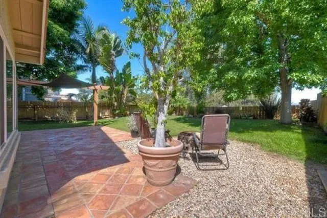 a view of a patio with table and chairs potted plants and tree