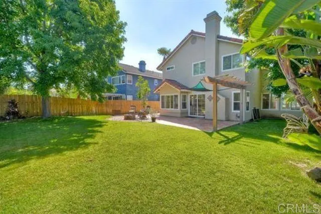 a view of a house with a yard deck and a small yard