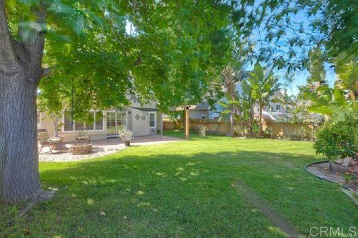 635 Boysenberry Way Oceanside, CA 92057 - Photo 19 of 21 a view of backyard with a table and chairs and a large tree