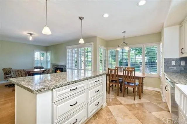 a kitchen with granite countertop a center island a dining table and chairs