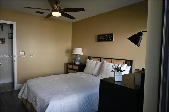 a bedroom with a bed and a lamp on the dresser