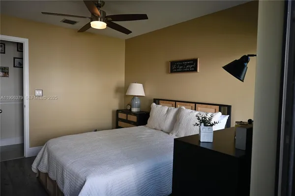 a bedroom with a bed and a lamp on the dresser