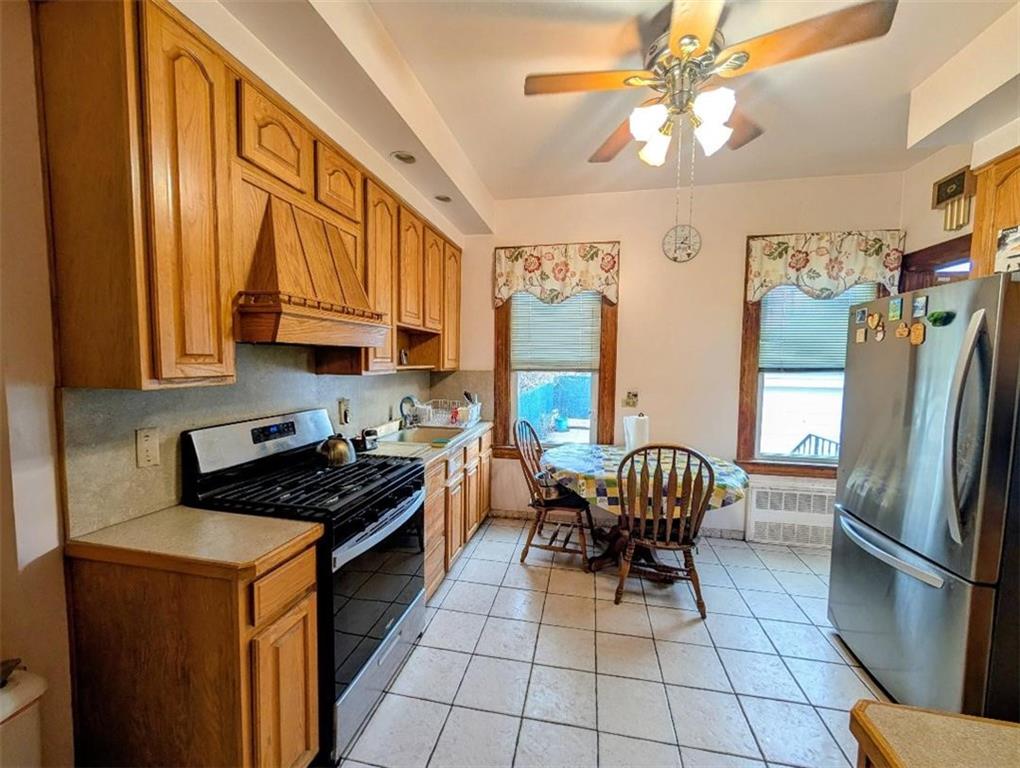 1735 West 11th Street Brooklyn, NY 11223 - Photo 5 of 14 a kitchen with stainless steel appliances granite countertop a refrigerator a sink a stove and a dining table