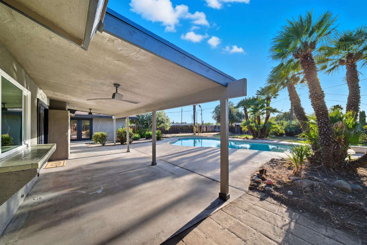 18578 Farallon Road Madera, CA 93638 - Photo 3 of 29 a view of a patio with table and chairs potted plants and palm trees