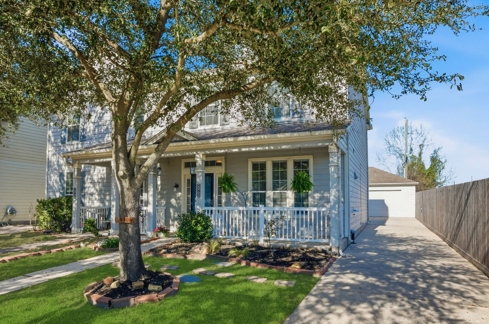 a view of a house with backyard garden and tree
