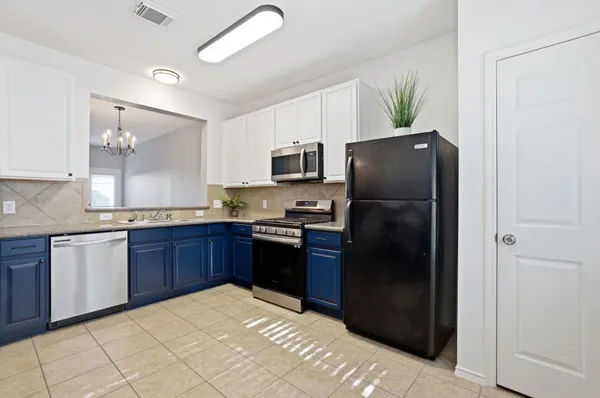 a kitchen with stainless steel appliances granite countertop a refrigerator stove and microwave