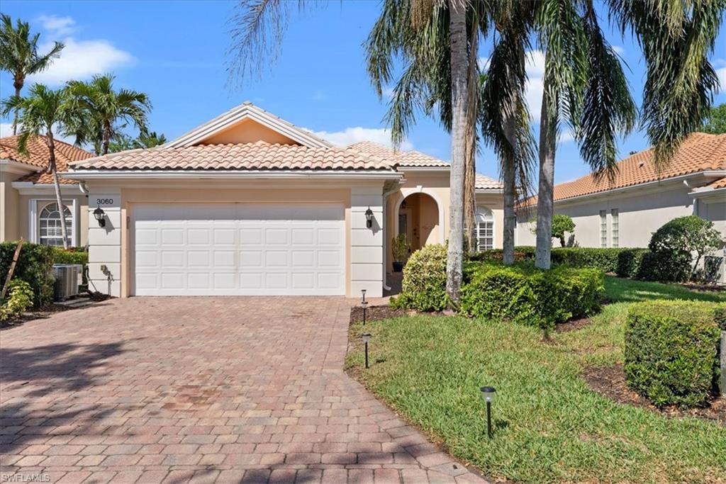 3060 Ellice Way Naples, FL 34119 - Photo 3 of 31 Mediterranean / spanish-style house featuring central air condition unit, stucco siding, an attached garage, a tiled roof, and decorative driveway