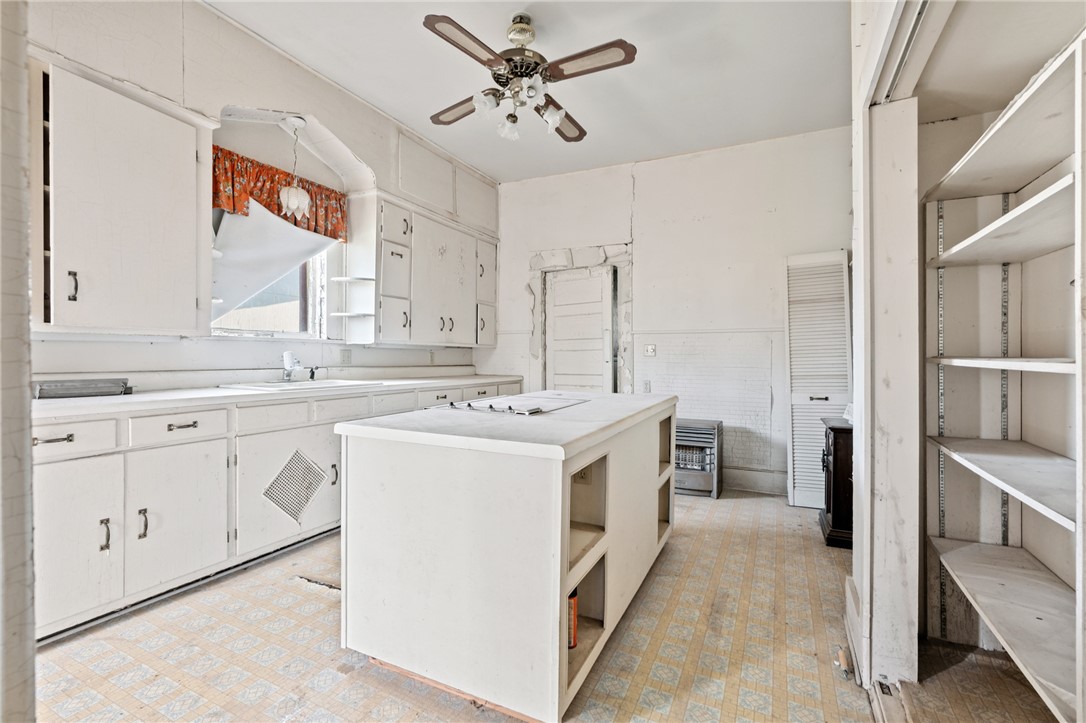 306 East Adams Street Itasca, TX 76055 - Photo 12 of 29 a kitchen with a stove sink and refrigerator