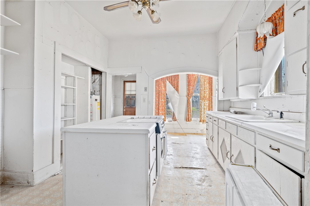 306 East Adams Street Itasca, TX 76055 - Photo 15 of 29 a large white kitchen with cabinets a sink and a window