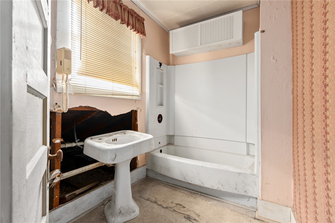 306 East Adams Street Itasca, TX 76055 - Photo 20 of 29 a bathroom with a sink a toilet and a bathtub