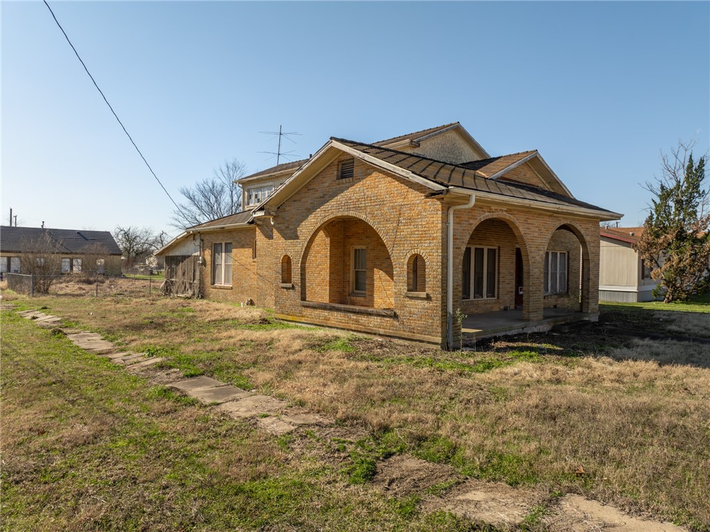 306 East Adams Street Itasca, TX 76055 - Photo 25 of 29 a front view of a house with a yard
