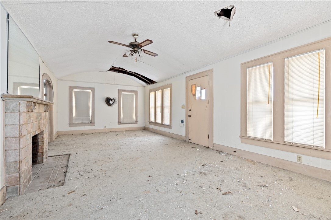 306 East Adams Street Itasca, TX 76055 - Photo 5 of 29 an empty room with windows and fireplace