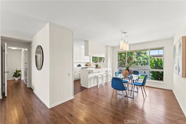 a kitchen with a table chairs refrigerator and cabinets