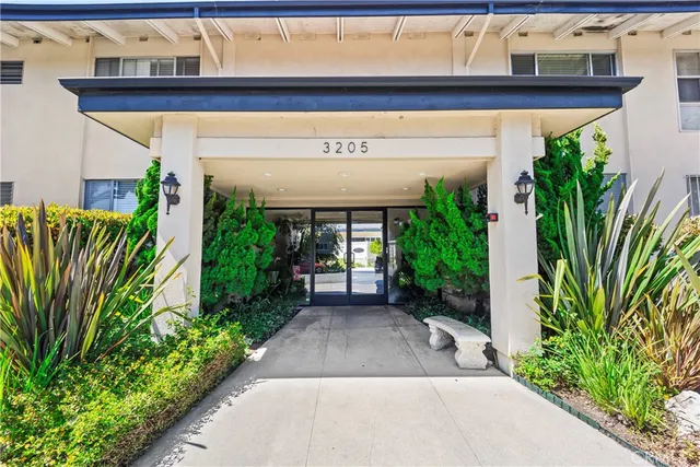 a view of a entryway door with flower pots