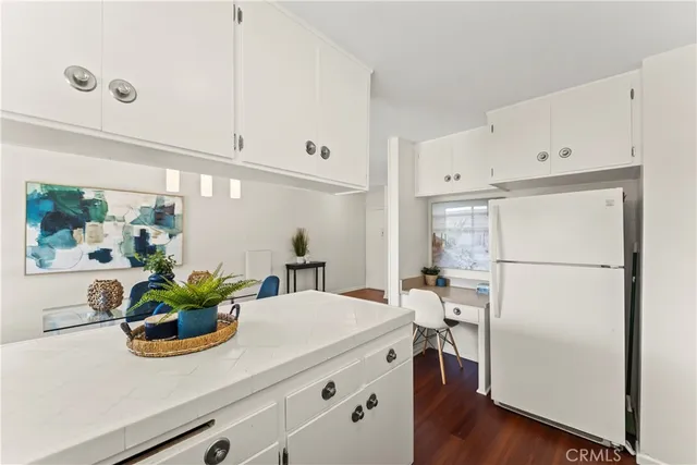 a room with stainless steel appliances white cabinets and wooden floor
