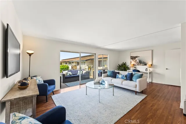 a living room with furniture flat screen tv and a large window