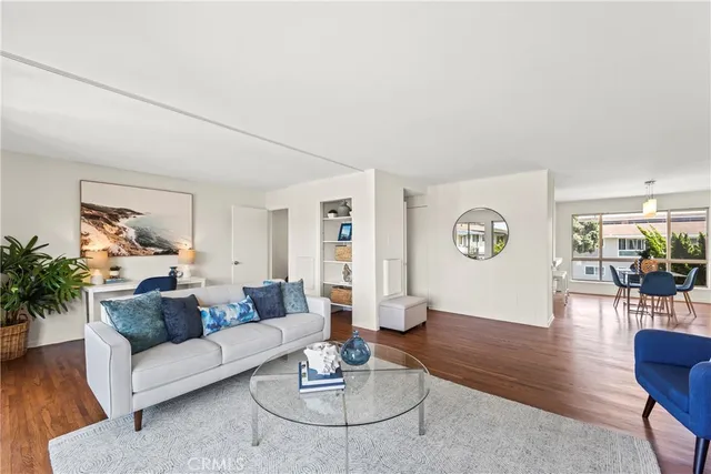 a living room with furniture a dining table and wooden floor
