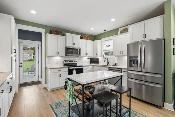 a kitchen with stainless steel appliances a refrigerator stove microwave and cabinets