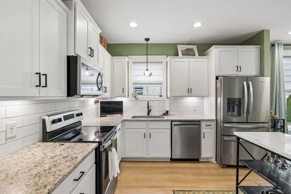 a kitchen with stainless steel appliances granite countertop a sink stove and refrigerator