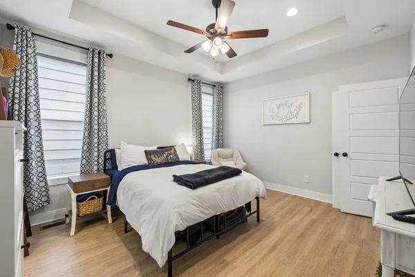 a bedroom with a bed chandelier and a window