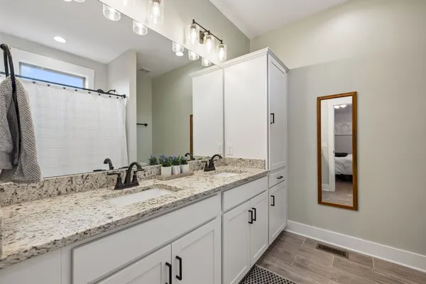 a bathroom with a granite countertop sink double and mirror
