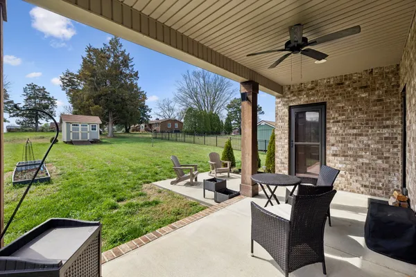 a living room with patio furniture and a swimming pool