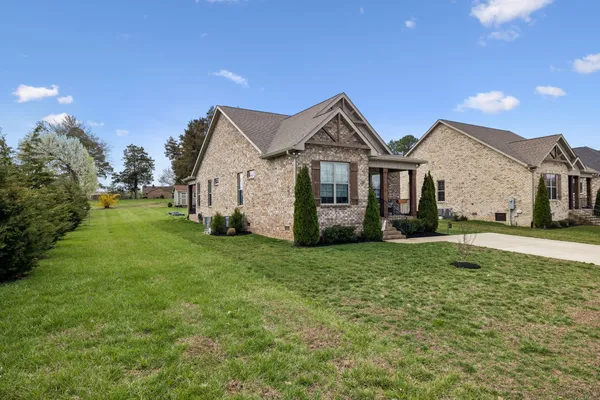 a front view of a house with a garden and yard