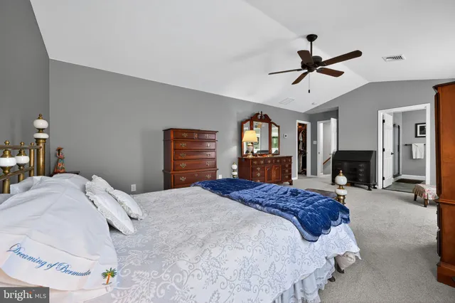 a bedroom with a large bed a flat tv screen and dresser