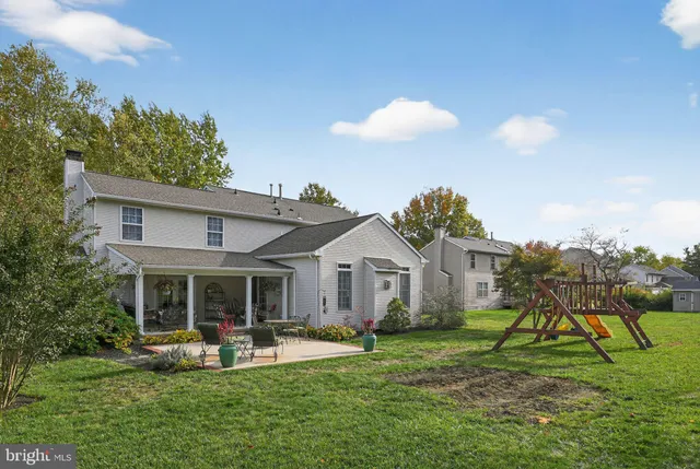 a view of house with backyard and outdoor seating