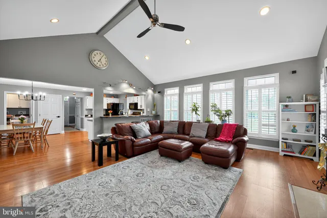 a living room with furniture kitchen view and a large window