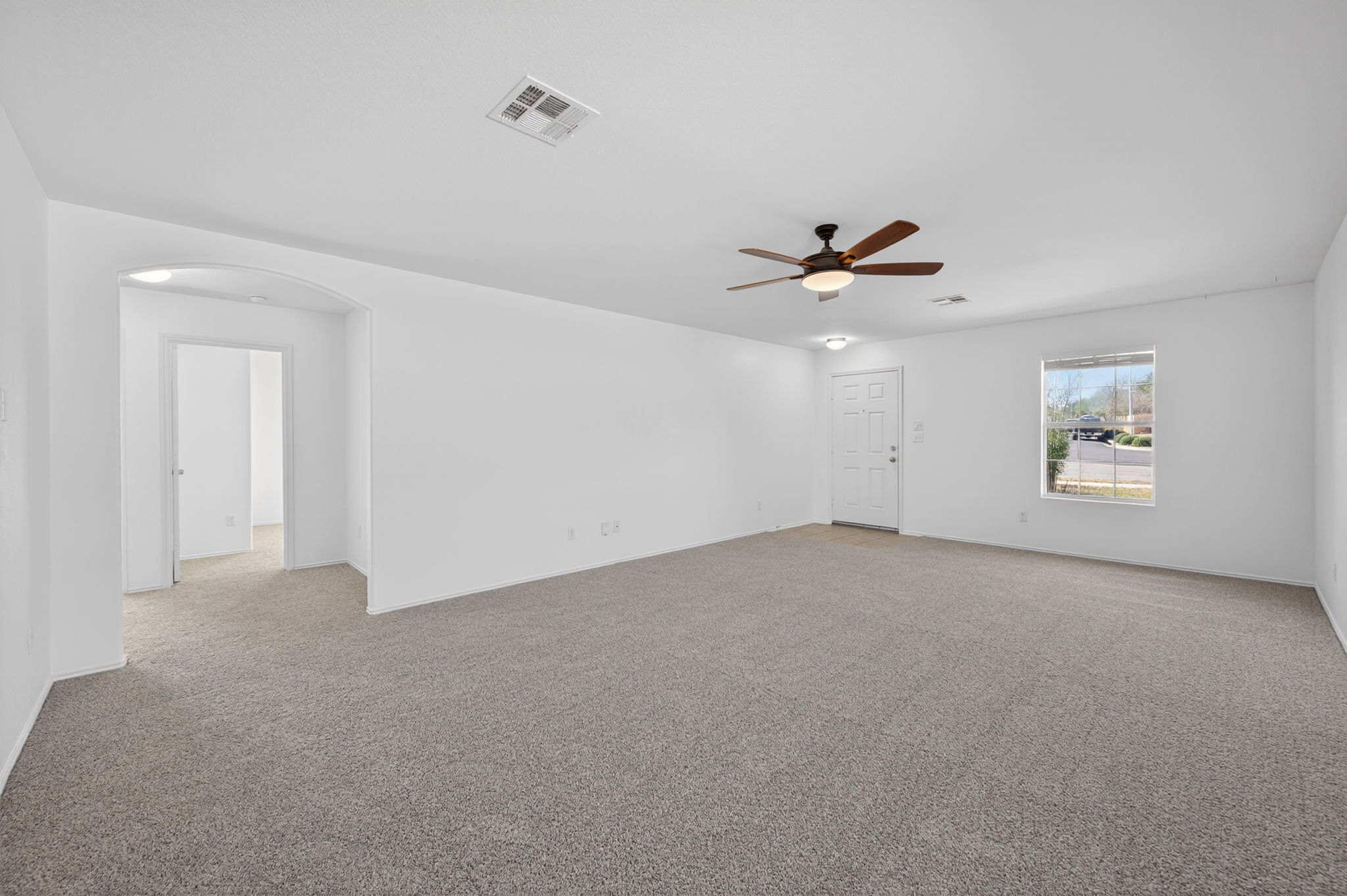 13629 Coomer Path Pflugerville, TX 78660 - Photo 5 of 30 Empty room featuring arched walkways, a ceiling fan, and light colored carpet
