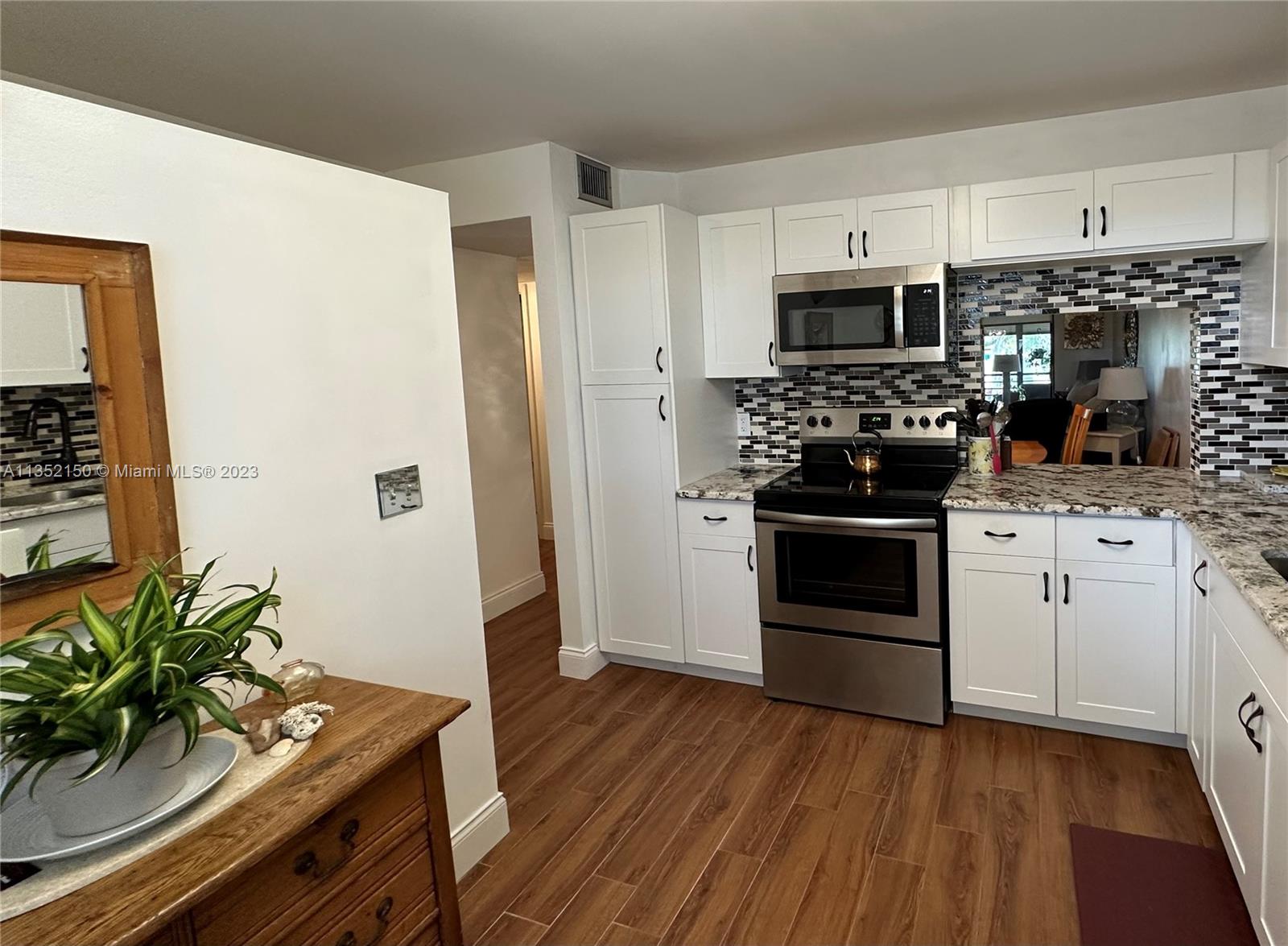 250 Gate Road, Unit 258 Hollywood, FL 33024 - Photo 11 of 30 a kitchen with stainless steel appliances a white stove top oven and a refrigerator