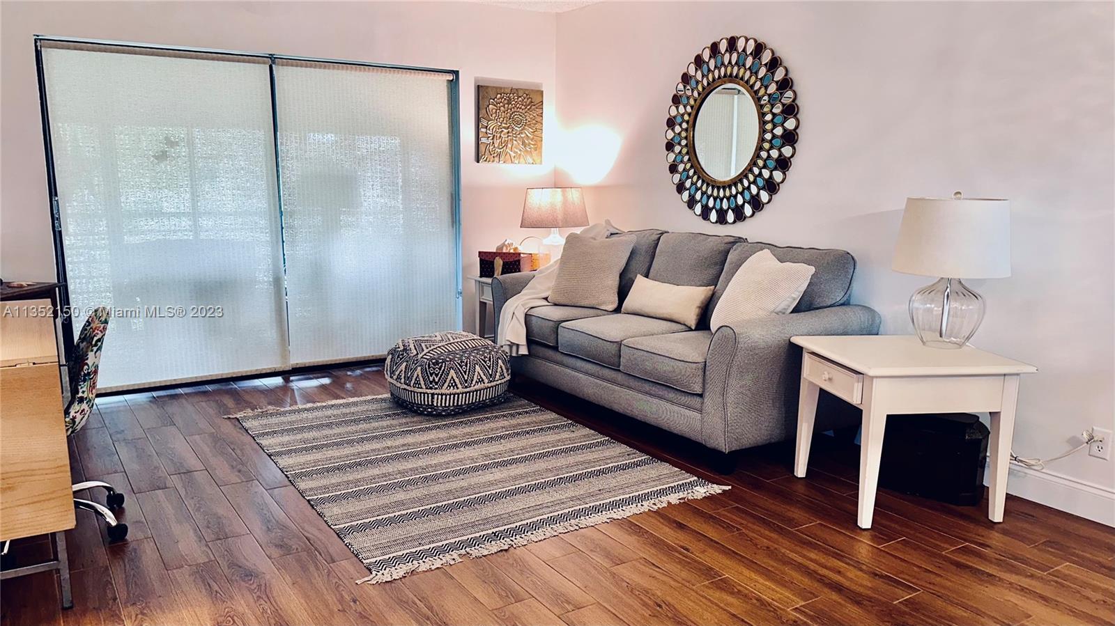 250 Gate Road, Unit 258 Hollywood, FL 33024 - Photo 2 of 30 a bedroom with a bed and wooden floor