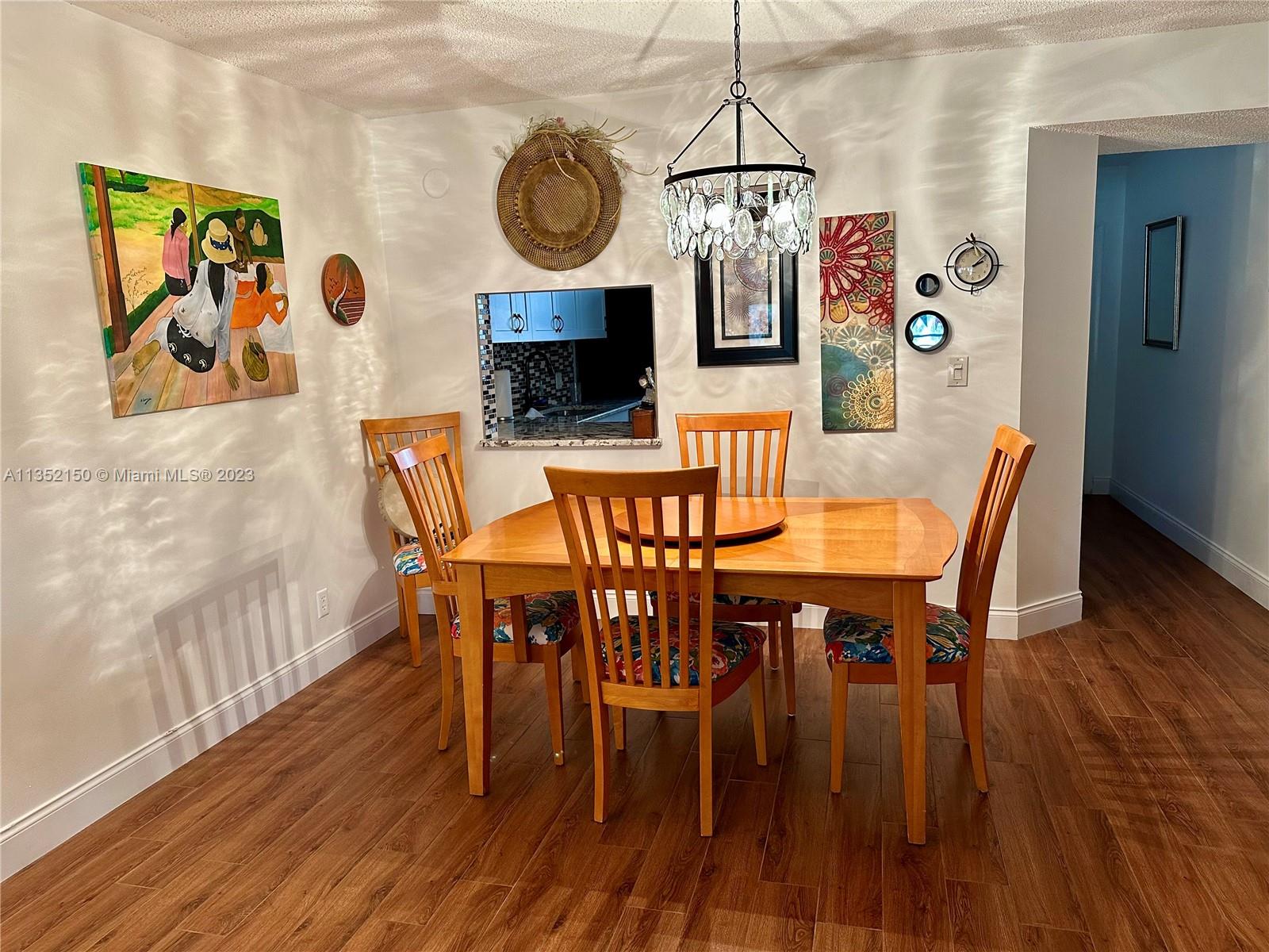 250 Gate Road, Unit 258 Hollywood, FL 33024 - Photo 5 of 30 a view of a dining room with furniture wooden floor and chandelier