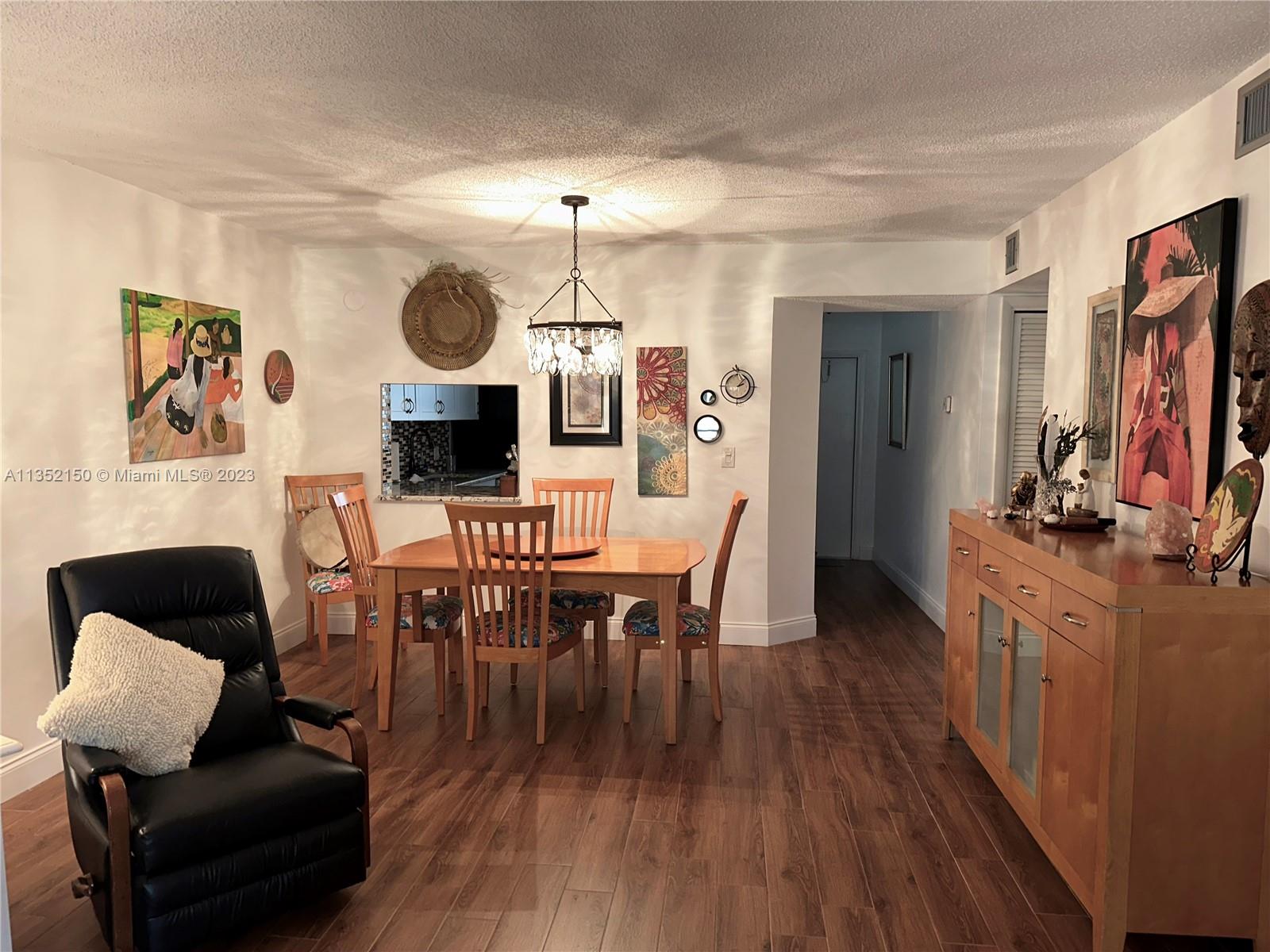 250 Gate Road, Unit 258 Hollywood, FL 33024 - Photo 7 of 30 a view of a dining room with furniture and wooden floor
