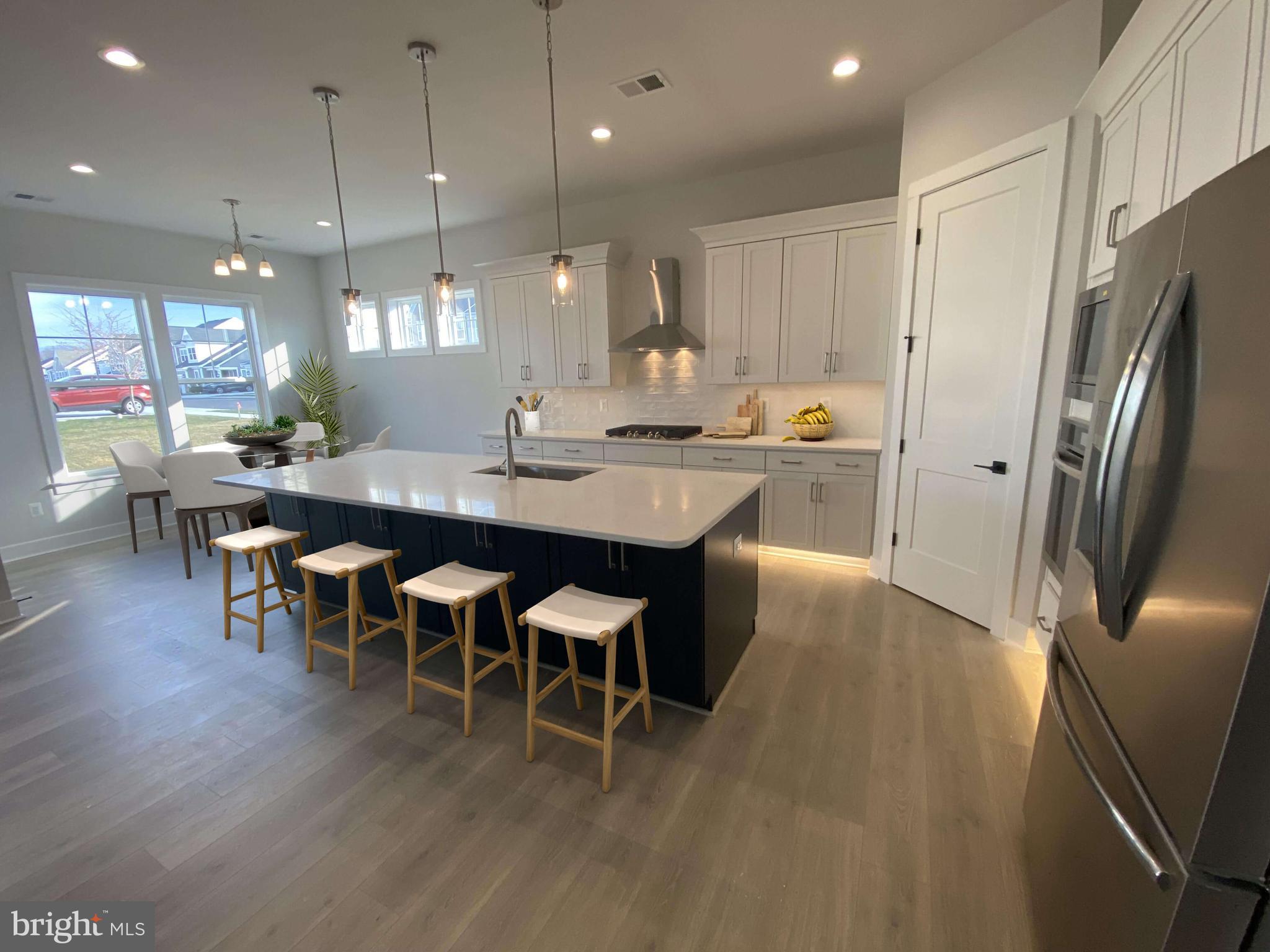53 Gentle Slope Way Gettysburg, PA 17325 - Photo 27 of 29 a kitchen with stainless steel appliances granite countertop a refrigerator a stove a sink a dining table and chairs with wooden floor